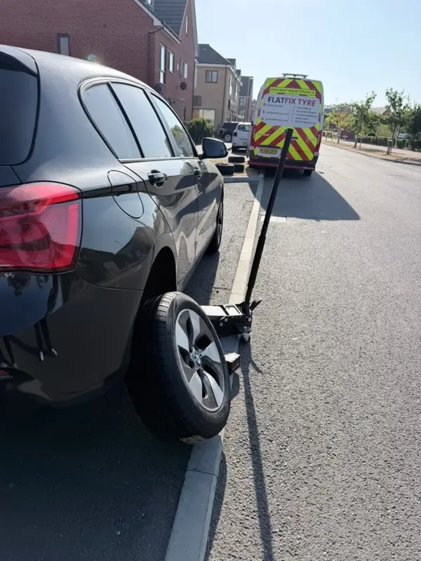 FlatFix Tyre technician changing and balancing an alloy car wheel on-site in London