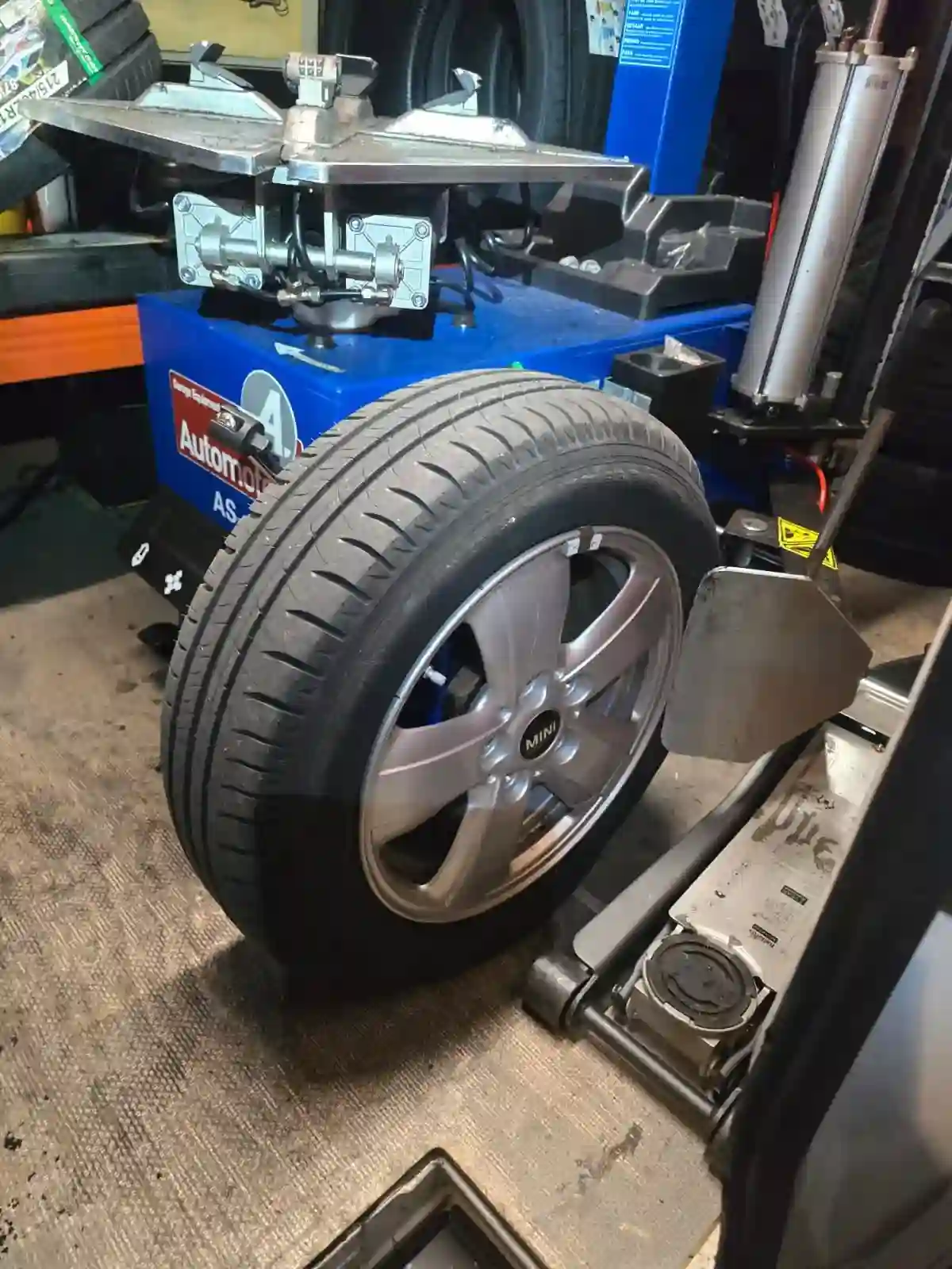 Mobile tyre technician using digital wheel balancing and bead seating machinery inside service van