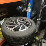 Technician preparing replacement car tyre on fitting machine in London